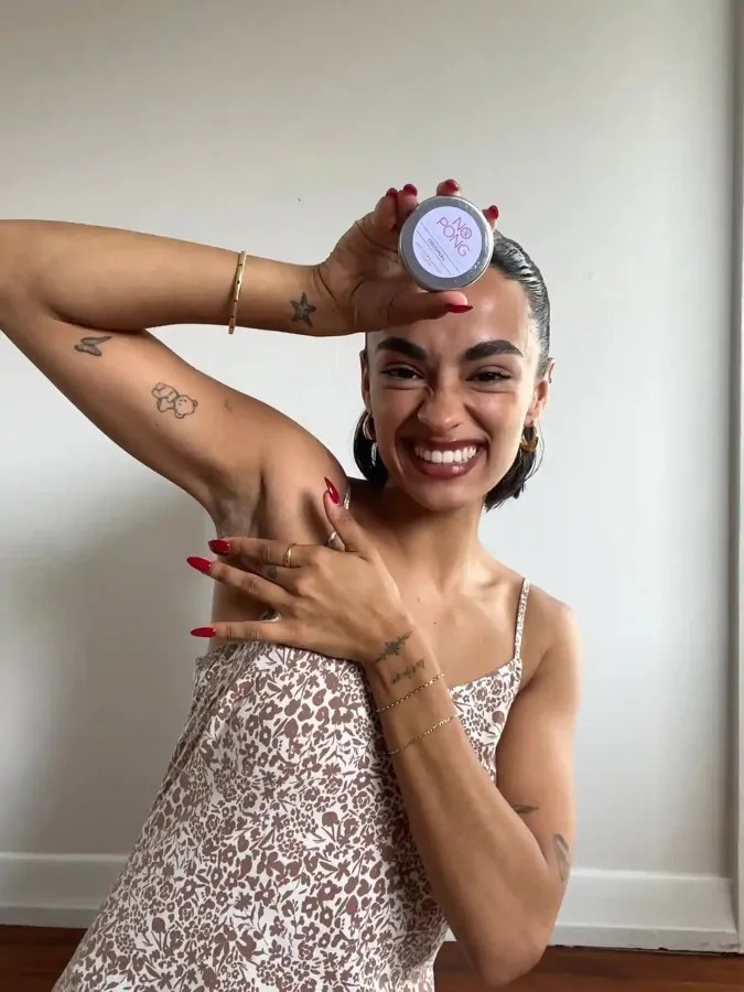 Customer holding a tin of No Pong natural deodorant up to the camera